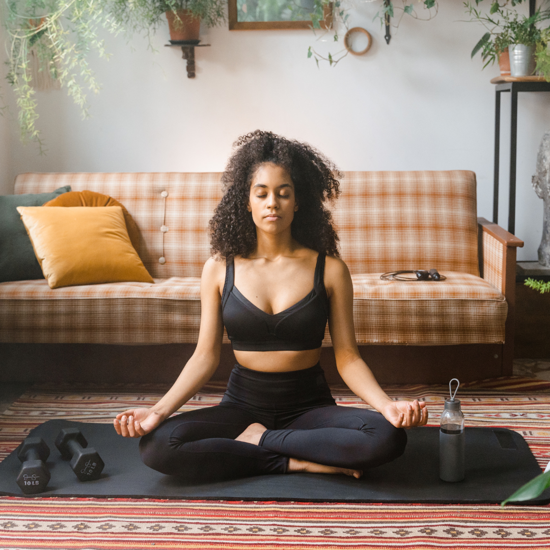 woman sitting in living room meditating