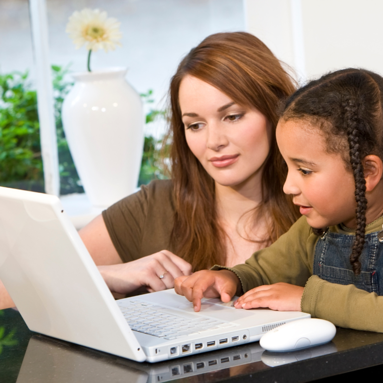 woman helping daughter with school work on the computer