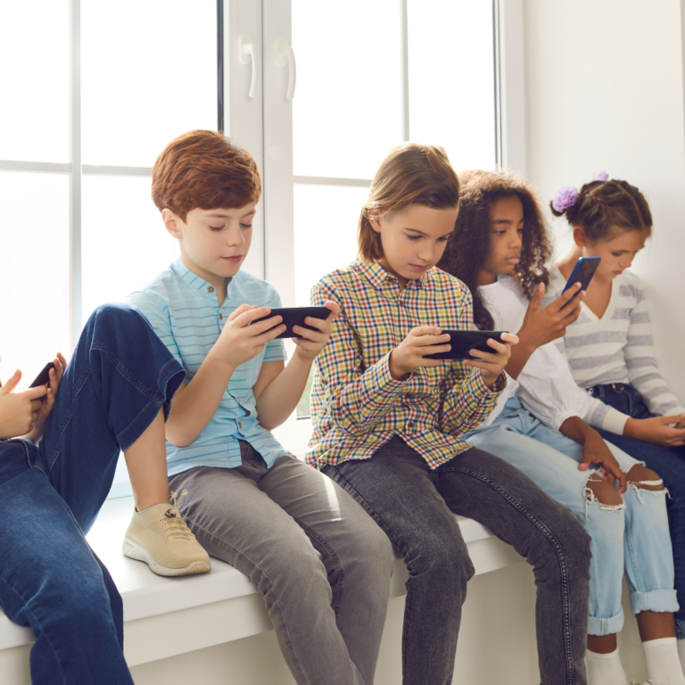 row of children playing on mobile devices
