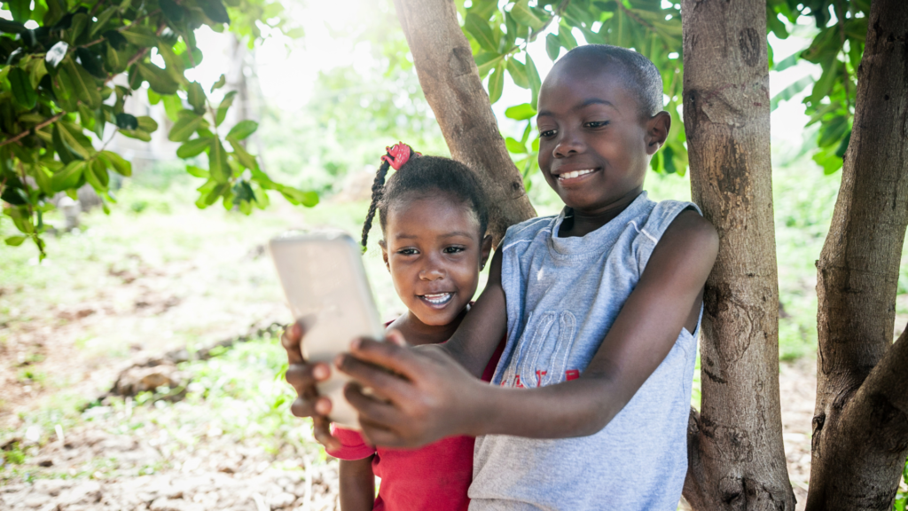 two smiling children tkaing a picture of themselves