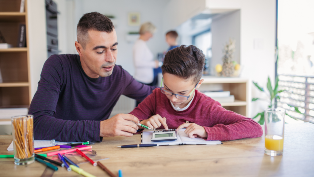 dad helping son with homework at the table